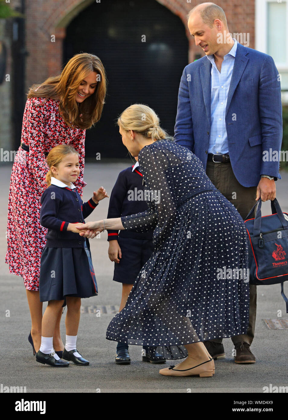 Helen Haslem, Leiter der unteren Schule grüßt Prinzessin Charlotte wie kommt sie für ihren ersten Tag in der Schule, mit ihrem Bruder Prinz George (versteckt) und ihre Eltern den Herzog und die Herzogin von Cambridge, bei Thomas von Battersea in London. Stockfoto