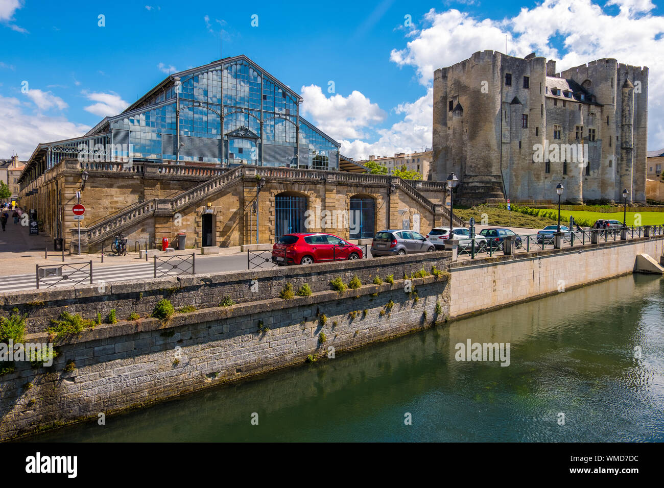 Niort, Frankreich - 11. Mai 2019: Halle und quadratischen Turm der romanische Bergfried auf der Bank von Sevres Fluss in Niort, Alpes-de-Haute-Provence, Frankreich Stockfoto