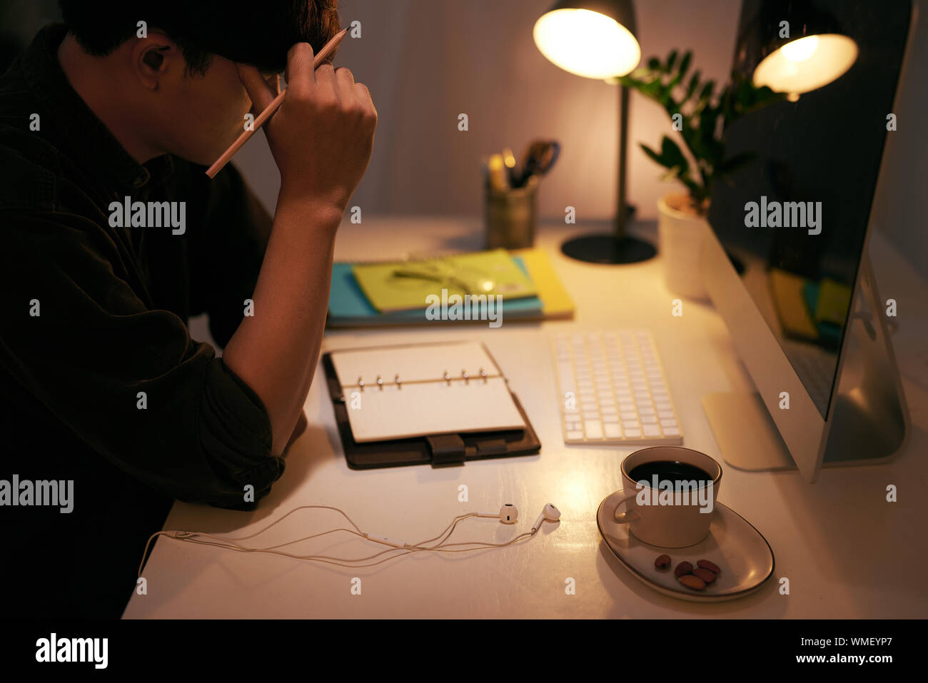 Ein Geschäftsmann zu denken, während an seinem Schreibtisch sitzen Stockfoto