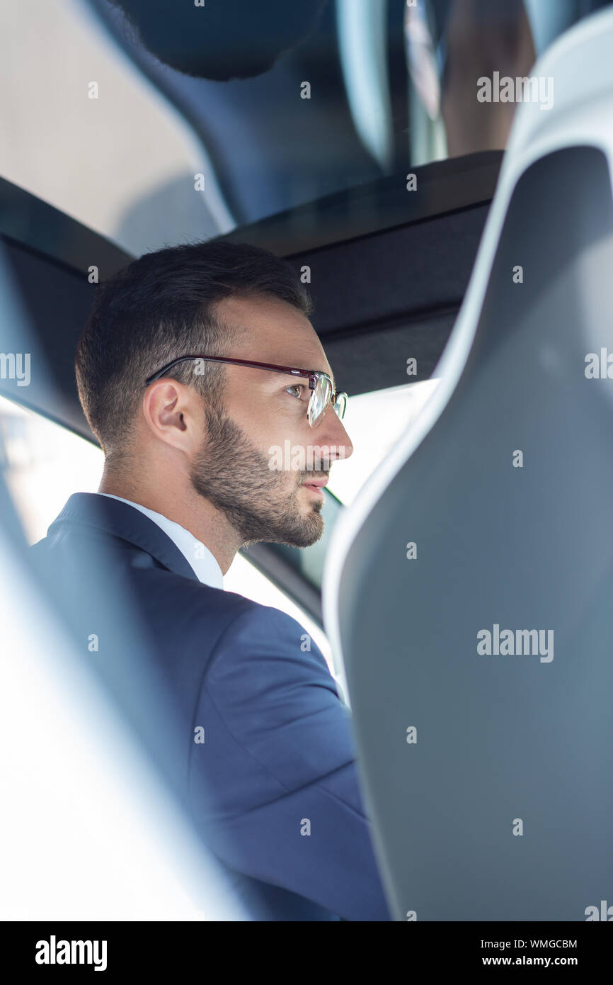 Gut aussehender bärtiger Mann Brille trägt mit seinem Auto fährt Stockfoto