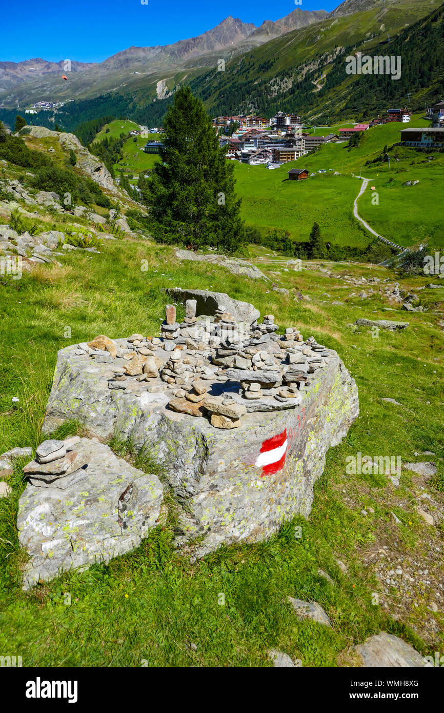 Haufen von Steinen und waymarker auf Rock, grünen Bergen und blauem sonnigen Tag in Obergurgl, Ötztal, Österreich, Stockfoto