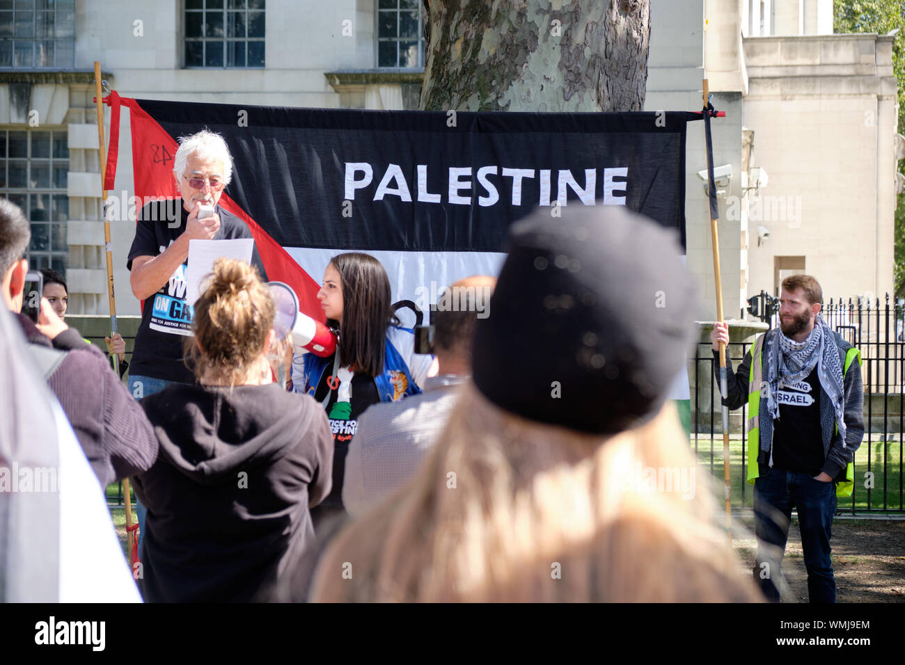 London, Großbritannien. September 2019. Glyn Secker spricht Hunderte an, die mit Schildern und Flaggen versammelt sind, um das spontane Treffen der Führer unter schwerer Polizeiüberwachung anzuprangern Pro-palästinensische Unterstützer in London ziehen sich über die Downing Street 10, um gegen den Besuch des israelischen Premierministers zu protestieren Stockfoto