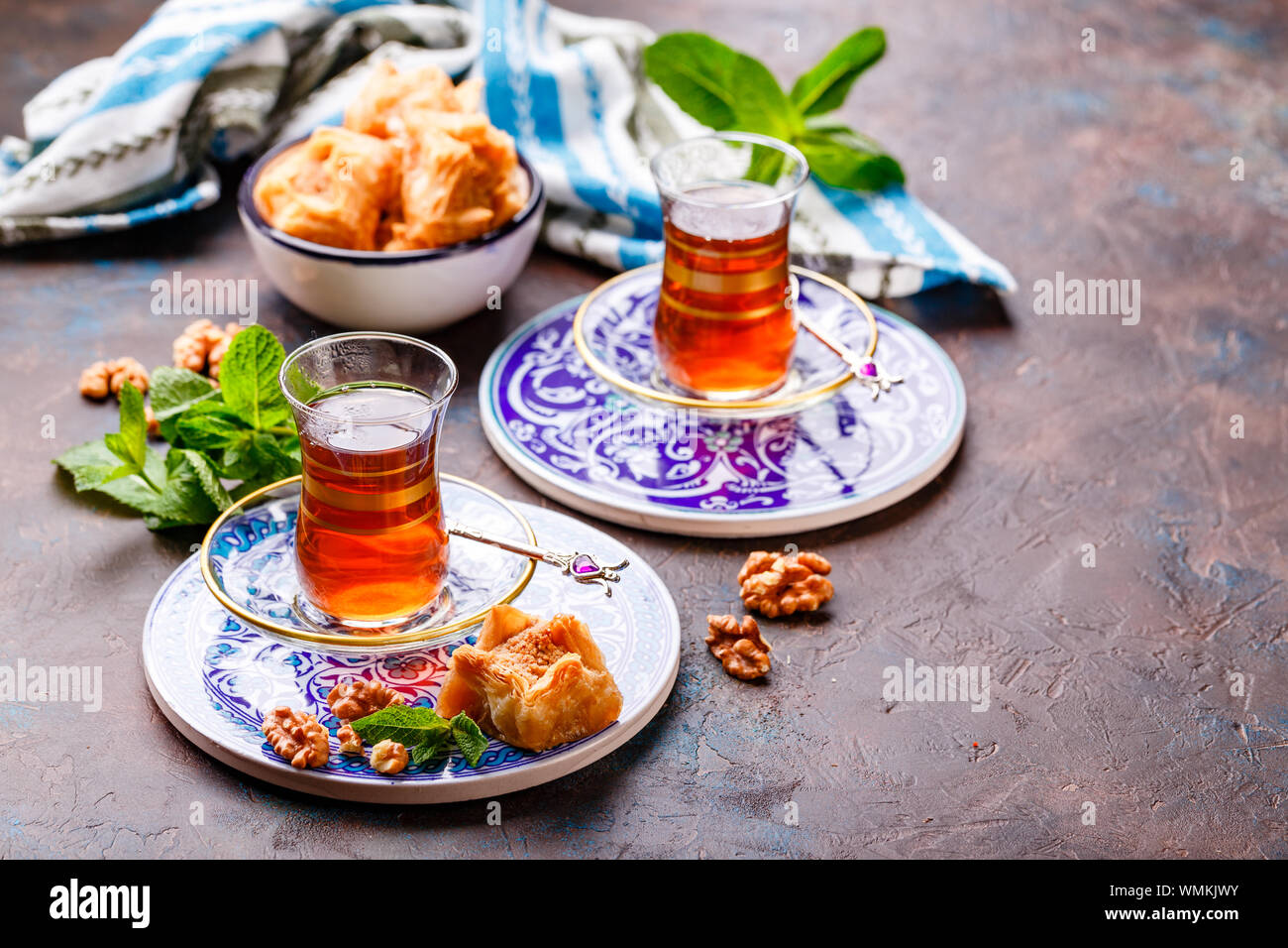 Im Nahen und Mittleren Osten oder arabischen Tee mit Minze in einem traditionellen Glas Schale und Türkische Süßigkeit Baklava. Ramadan Kareem. Eid Mubarak. Islamische Feiertage decorat Stockfoto