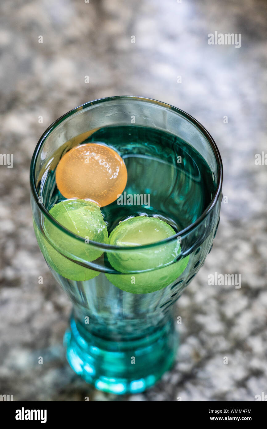 Coca Cola Glas mit bunten Ice Cube, stehend auf einem Granit Plattform. Hohen Winkel anzeigen, schließen. Stockfoto