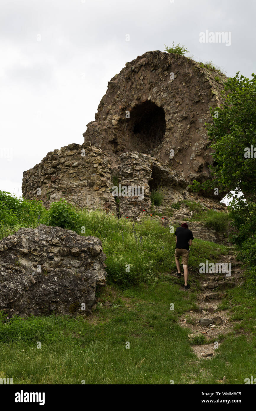 Ein junger Tourist in Richtung Auge der Hexe; die Reste der mittelalterlichen Engelbourg Schloss nahe der elsässischen Stadt Thann, Frankreich. Stockfoto