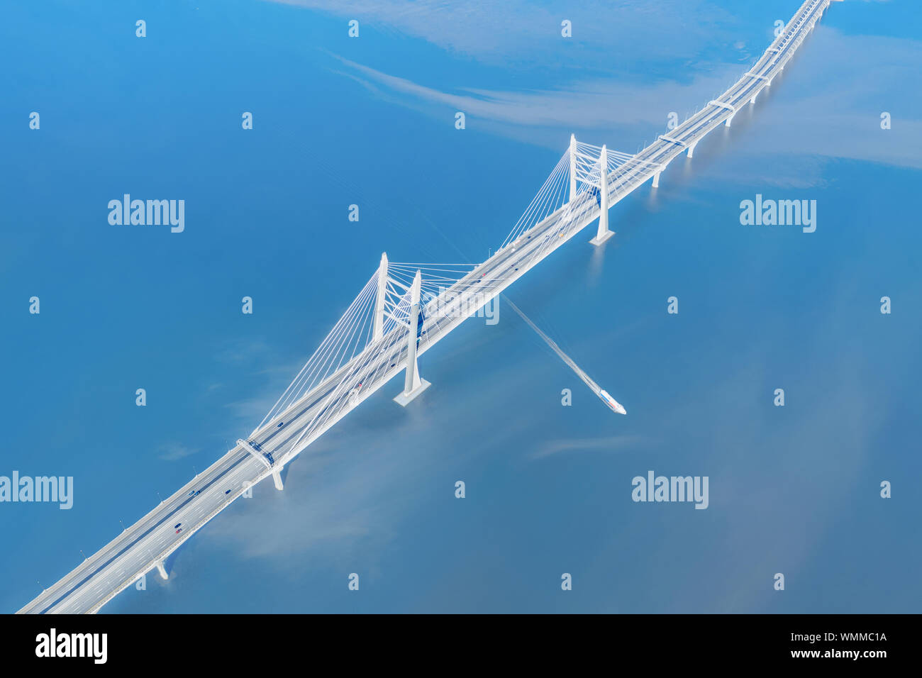 Geschwindigkeit Schiff vorbei unter große Schrägseilbrücke über die hochstraße Luftaufnahme. Hell blau Marine Stockfoto