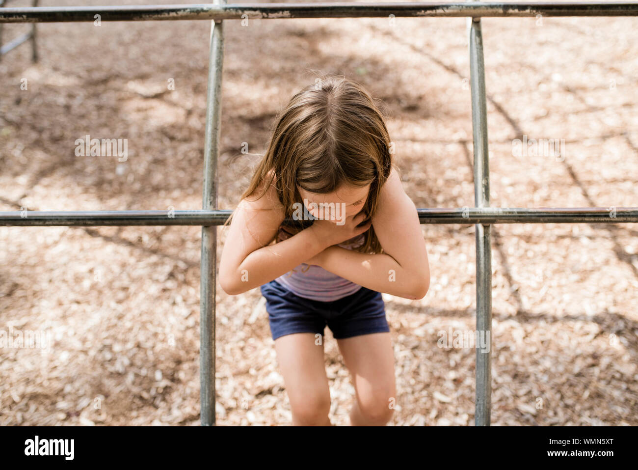 Junges Mädchen mit braunem Haar spielt auf Spielplatz im Sommer an einem sonnigen Tag Stockfoto