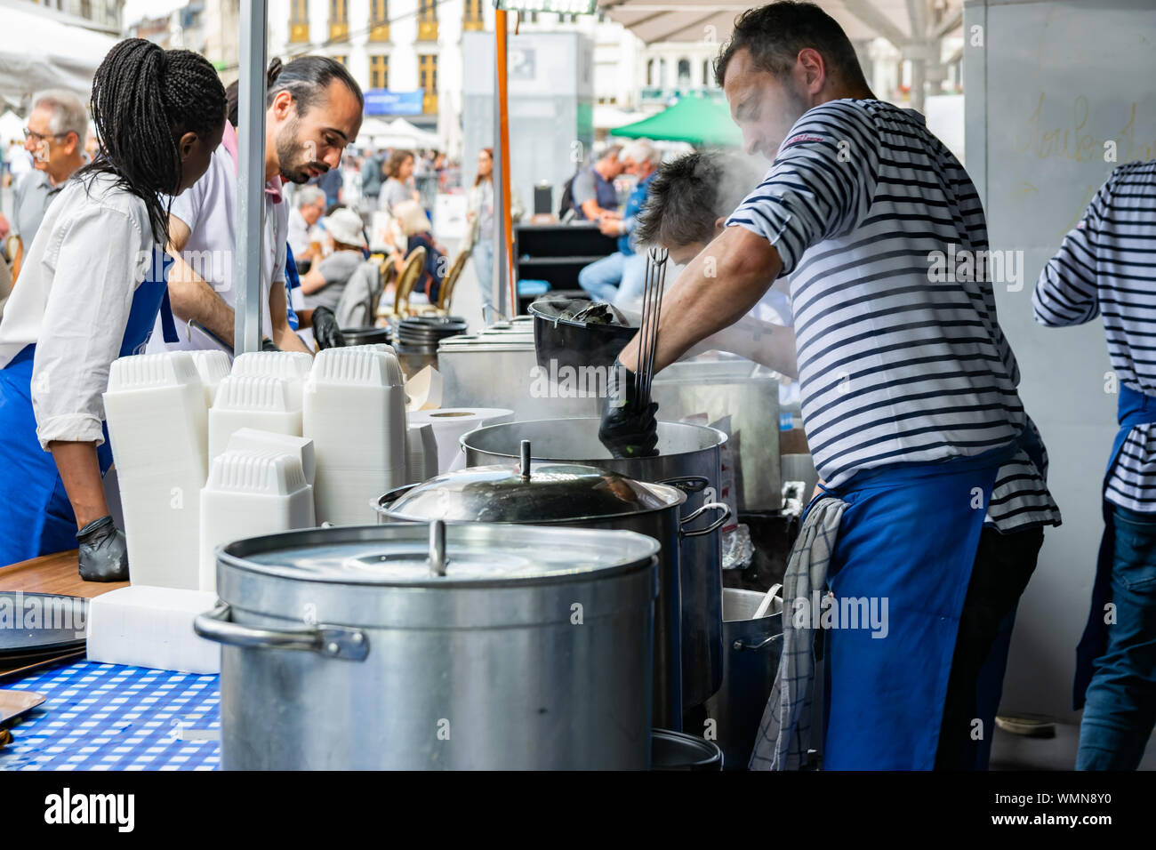 Lille, Frankreich - September 01,2019: Große Lille Braderie (Braderie de Lille). Das Personal im Restaurant traditionelle Gericht auf Lille Braderie, Muscheln und Pommes frites zubereiten. Stockfoto