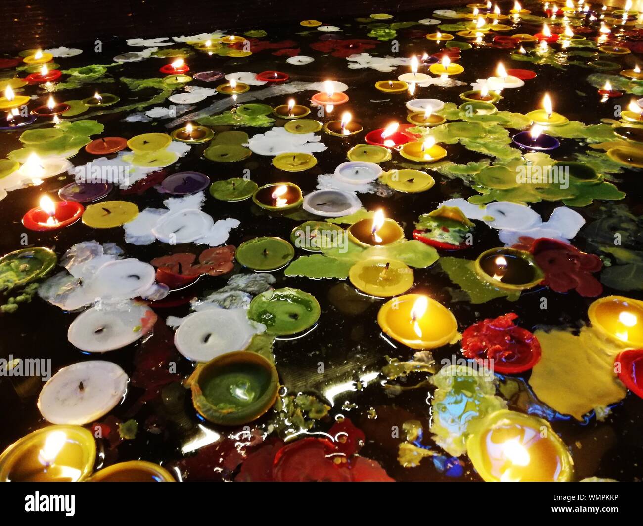 Hohen Winkel Blick auf das beleuchtete Teelichter und Blätter auf dem Wasser  schwimmend Stockfotografie - Alamy