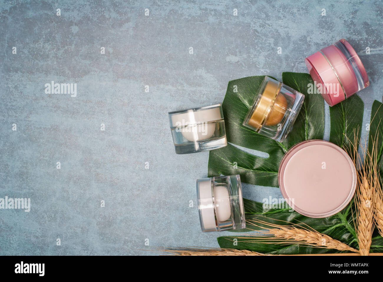 Kosmetisches Erzeugnis und tropische Blätter auf Konzert Hintergrund, kosmetisches Erzeugnis Stockfoto
