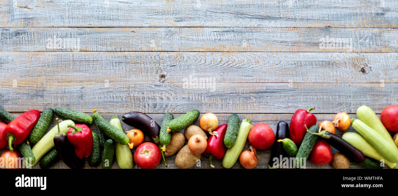 Herbst Ernte. Gemüse, Tomaten und Gurken, Karotten und Blumenkohl, Zucchini und Auberginen, Zwiebeln und Kartoffeln auf einem alten Holz- Hintergrund. Stockfoto
