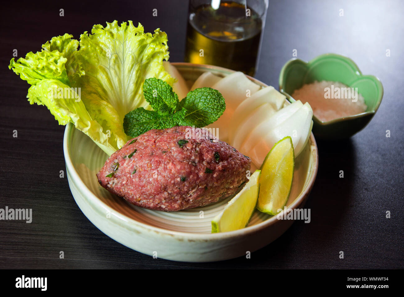 Raw kibbeh libanesische Küche. Kibbeh nayeh. Traditionelle arabische Lebensmittel mit Zwiebeln, Kalk, Kopfsalat und Pfefferminze Blätter. Stockfoto