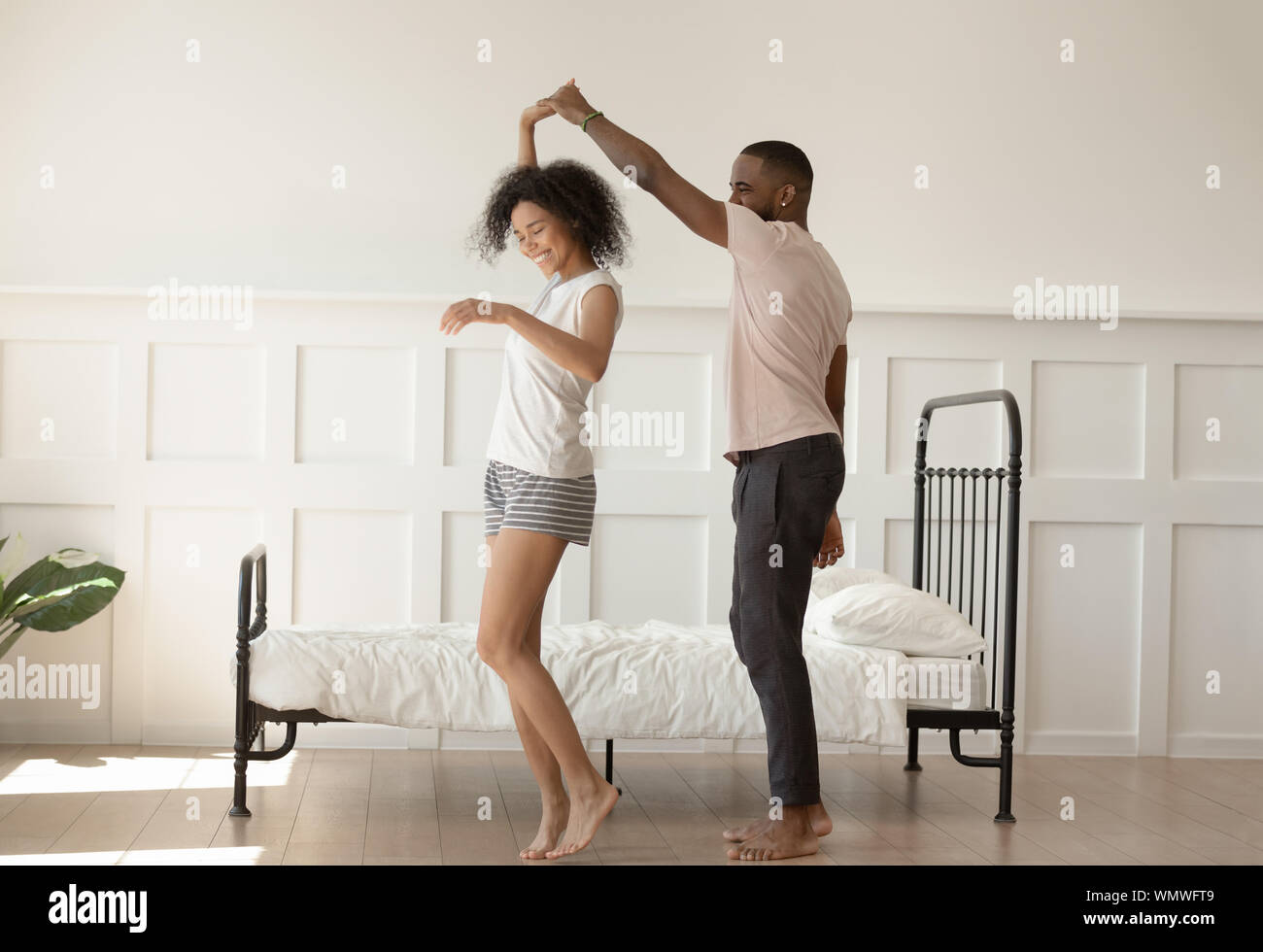 Gerne barfuß african american liebevolle Familie Paar tanzen im Schlafzimmer. Stockfoto