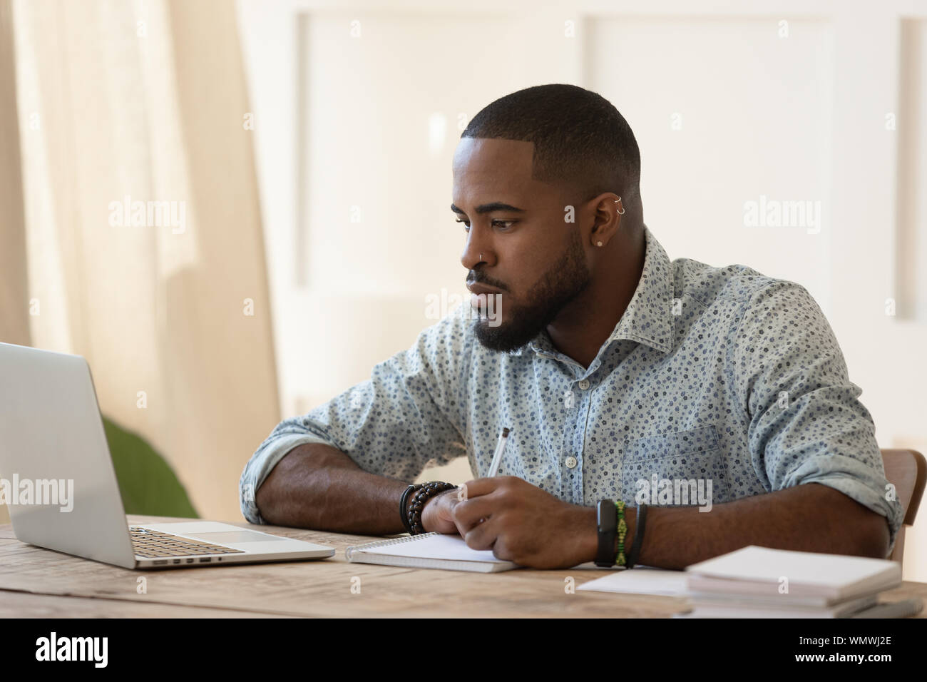 Tausendjährigen afrikanischen amerikanischen Kerl auf on-line-Universität Kurse konzentriert konzentriert. Stockfoto