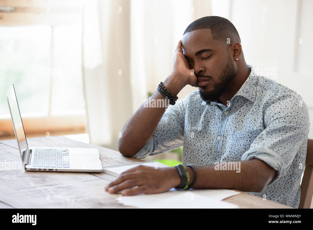 Müde african american man schlafen in die Vorderseite des Computers. Stockfoto