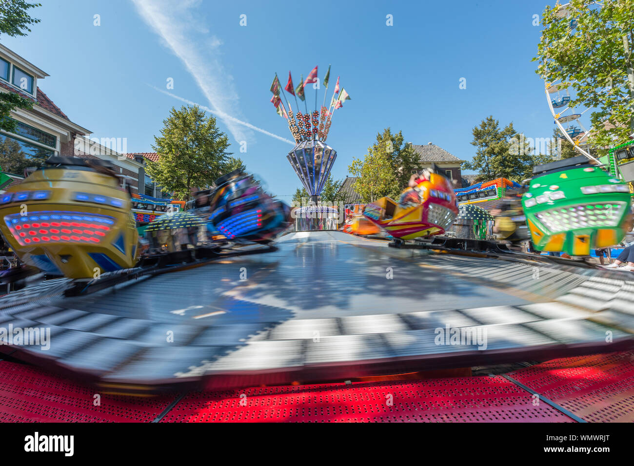 Fancy Fair mit großer Kreisverkehr, die schnell in der Sonne dreht an einem sonnigen Tag Stockfoto