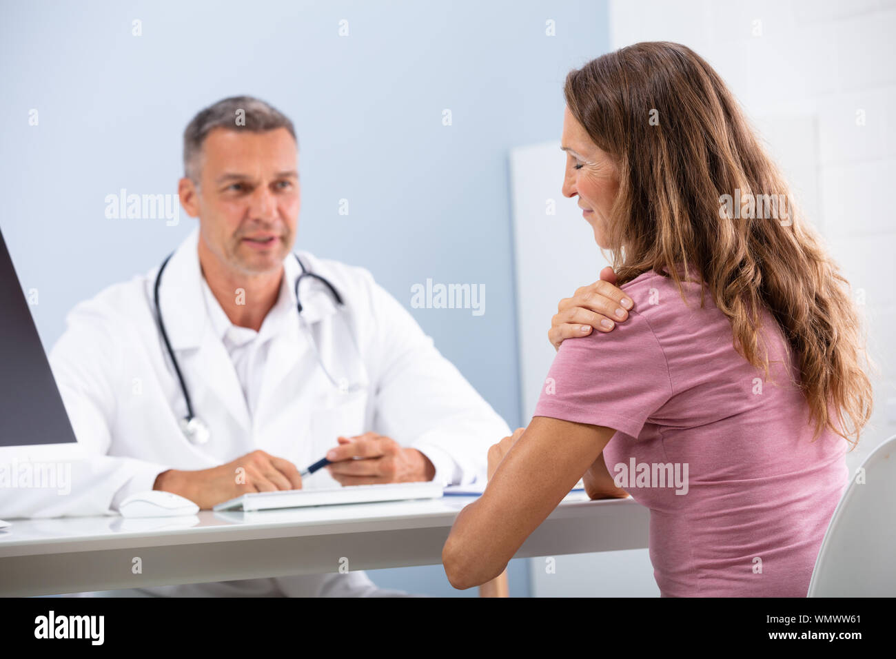 Reifen Arzt suchen Bei weiblichen Patienten zeigen Ihr Paining Schulter in Klinik Stockfoto Reifen Arzt suchen Bei weiblichen Patienten zeigen Ihr Paining Schulter in Klinik Stockfoto