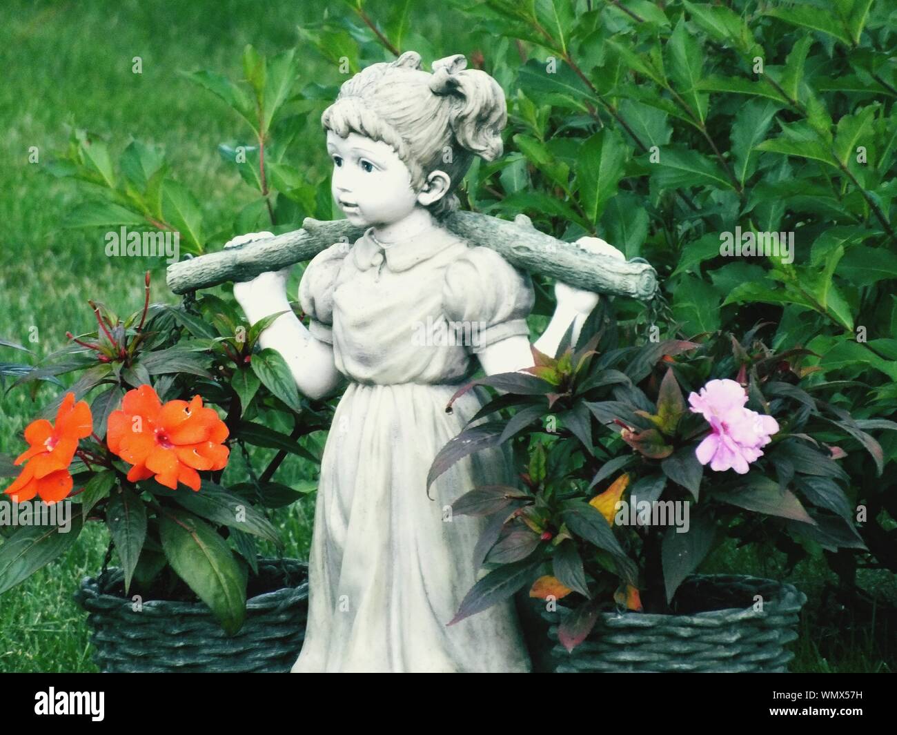 In der Nähe von Weißen weibliche Skulptur mit Blumenkorb in Park Stockfoto