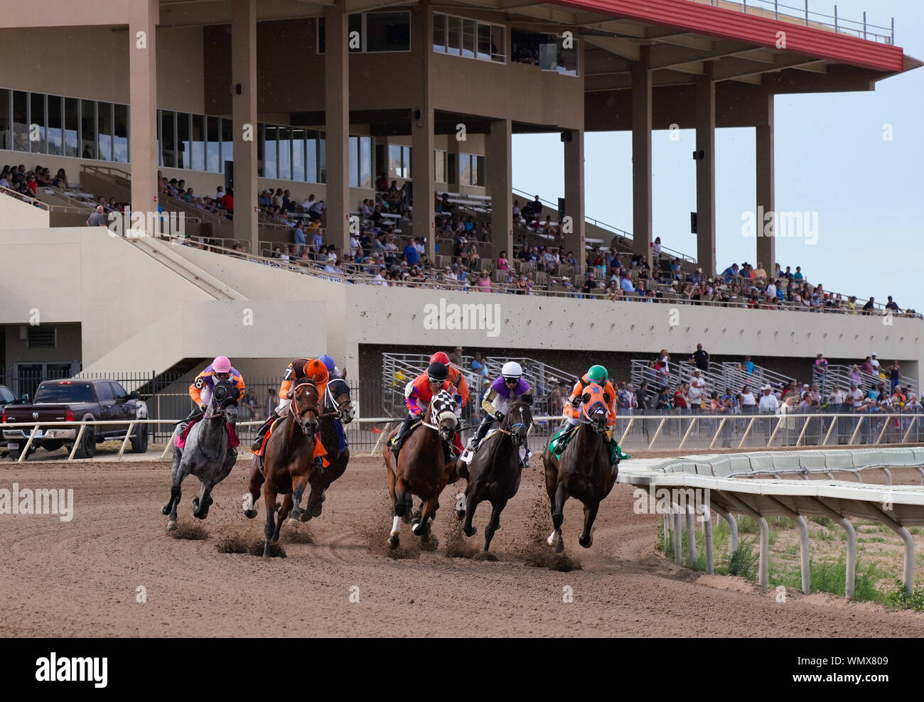 Pferde und Jockeys runden die ersten auf der Rennstrecke am Arizona Downs am 1. September 2019 biegen. Version 1 Stockfoto