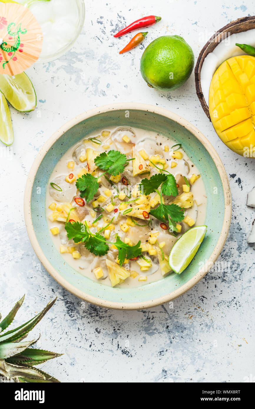 Raw Jakobsmuscheln als Vorspeise mit tropischen Früchten, whaite Hintergrund. Stockfoto