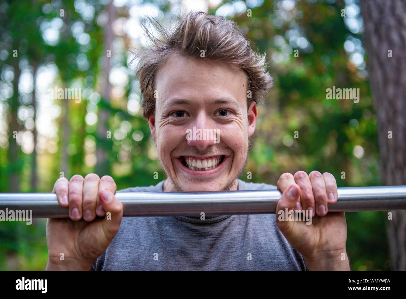 Junger Mann, Pull-ups auf ein Pull-up-Bar, Perlacher Forst, München, Bayern, Deutschland Stockfoto