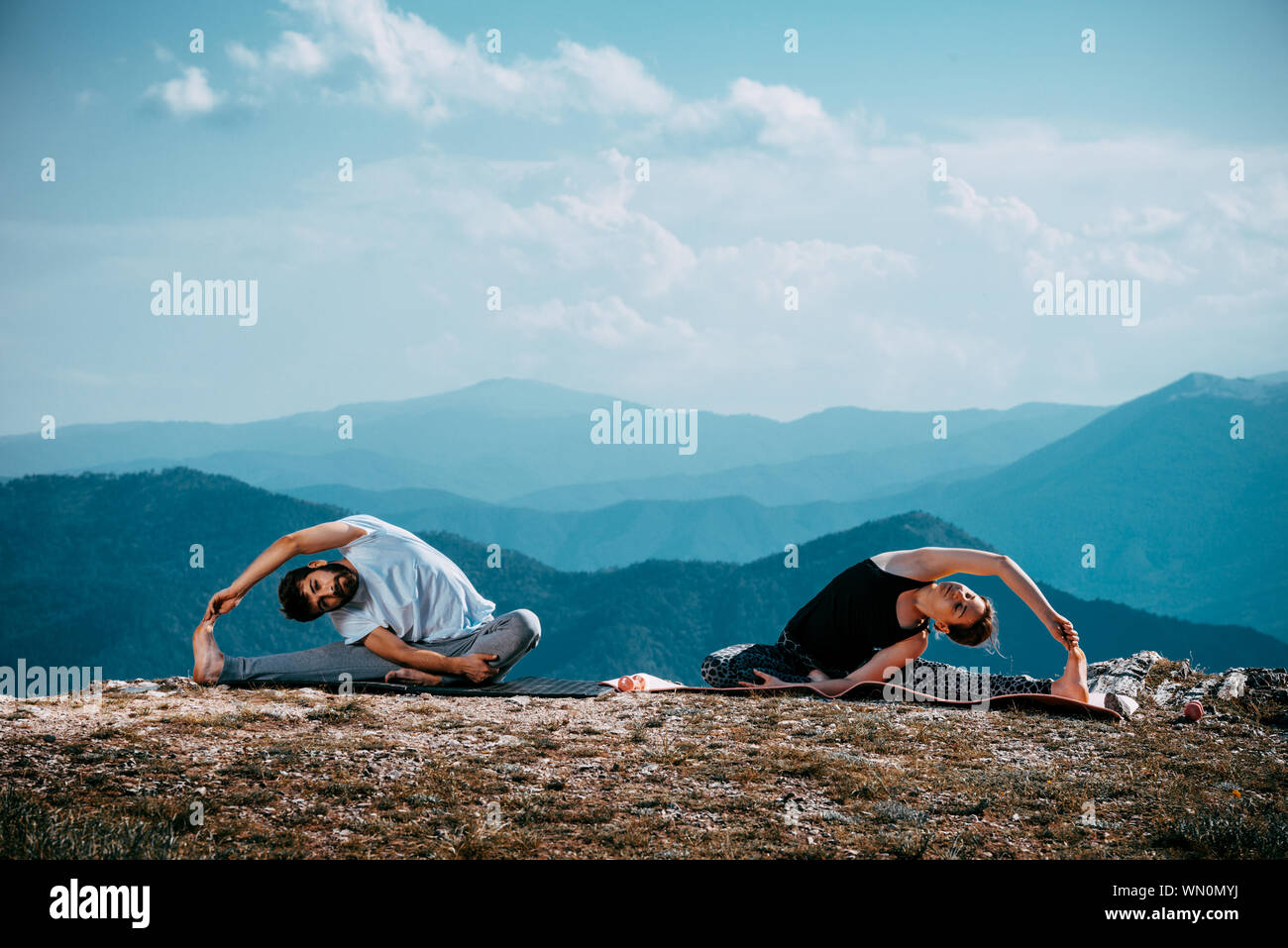 Paar Meditation Yoga in den Bergen. Reisen lifestyle Entspannung emotionale Konzept Abenteuer Sommer Ferien Stockfoto