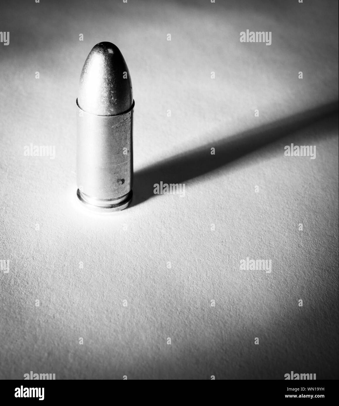 Einen einzigen Ständigen 9 mm bullet mit dramatischen Seite Licht und Schatten in Schwarz und Weiß Stockfoto