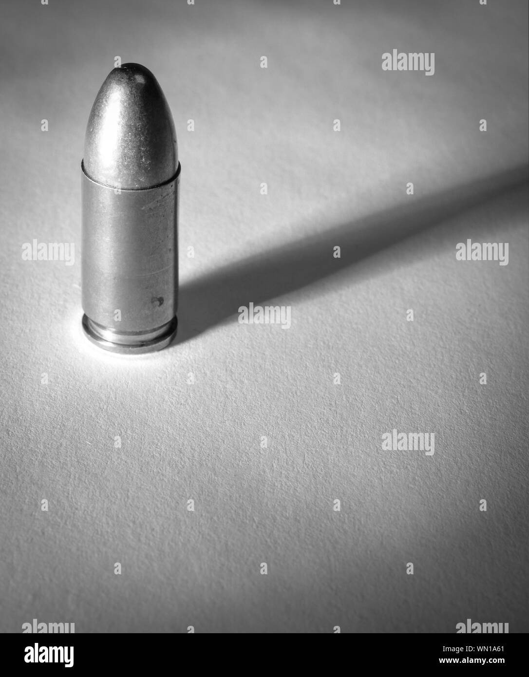 Einen einzigen Ständigen 9 mm bullet mit dramatischen Seite Licht und Schatten in Soft schwarz und whtie Stockfoto