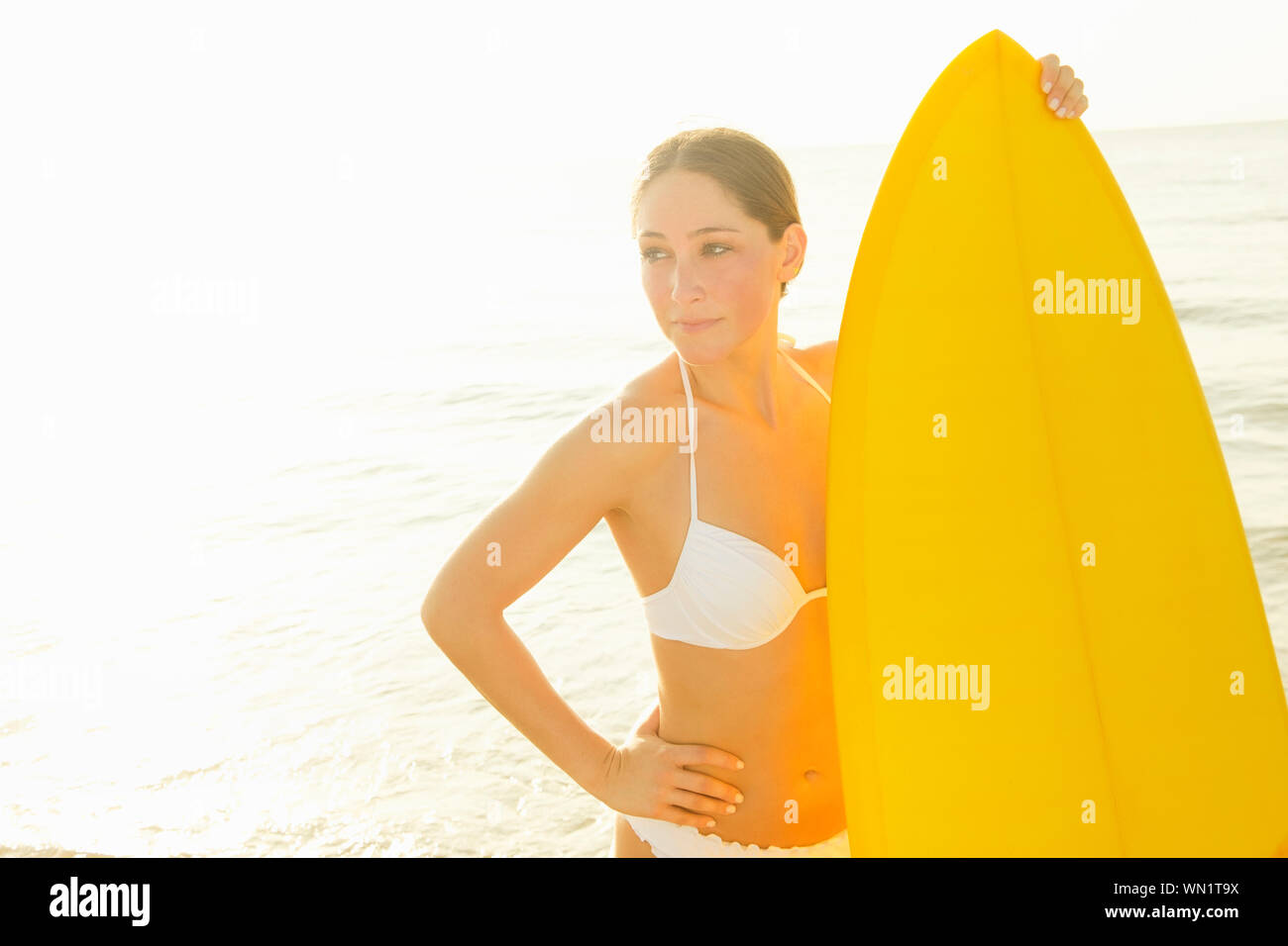 Frau tragen weiße bikini Holding surfboard Stockfoto