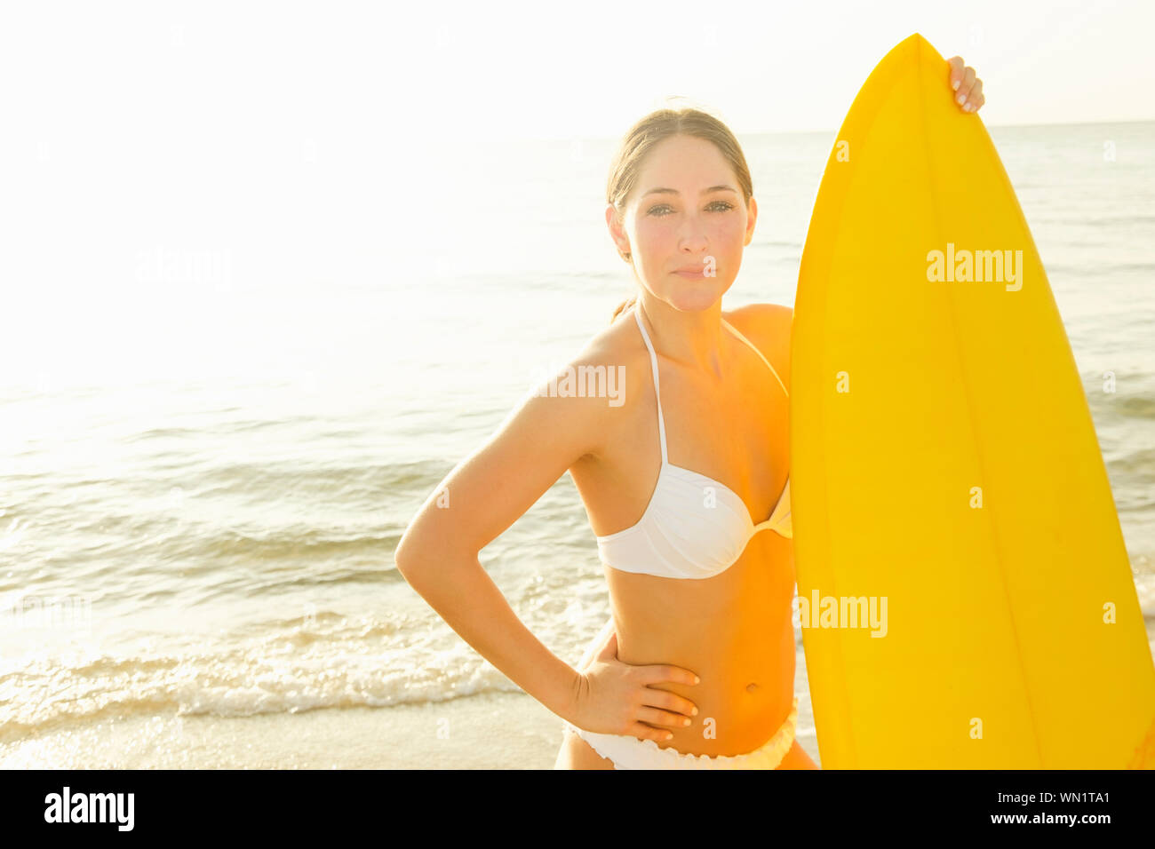 Frau tragen weiße bikini Holding surfboard Stockfoto