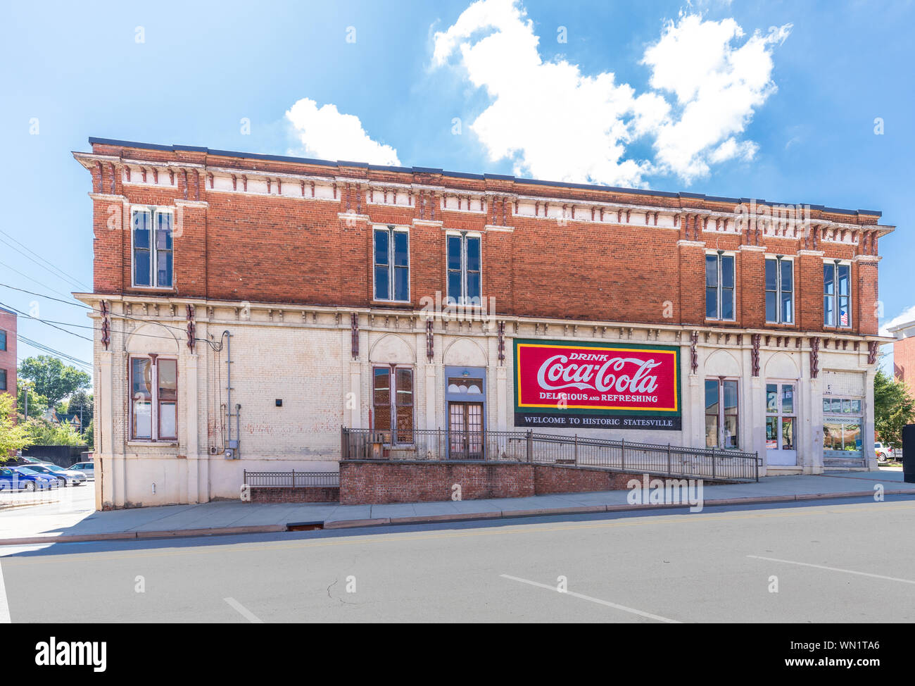 STATESVILLE, NC, USA-1 SEPTEMBER 2019: Ein altes Gebäude in der Innenstadt, mit Coca-cola ad und Schild "Willkommen in historischen Statesville'. Stockfoto