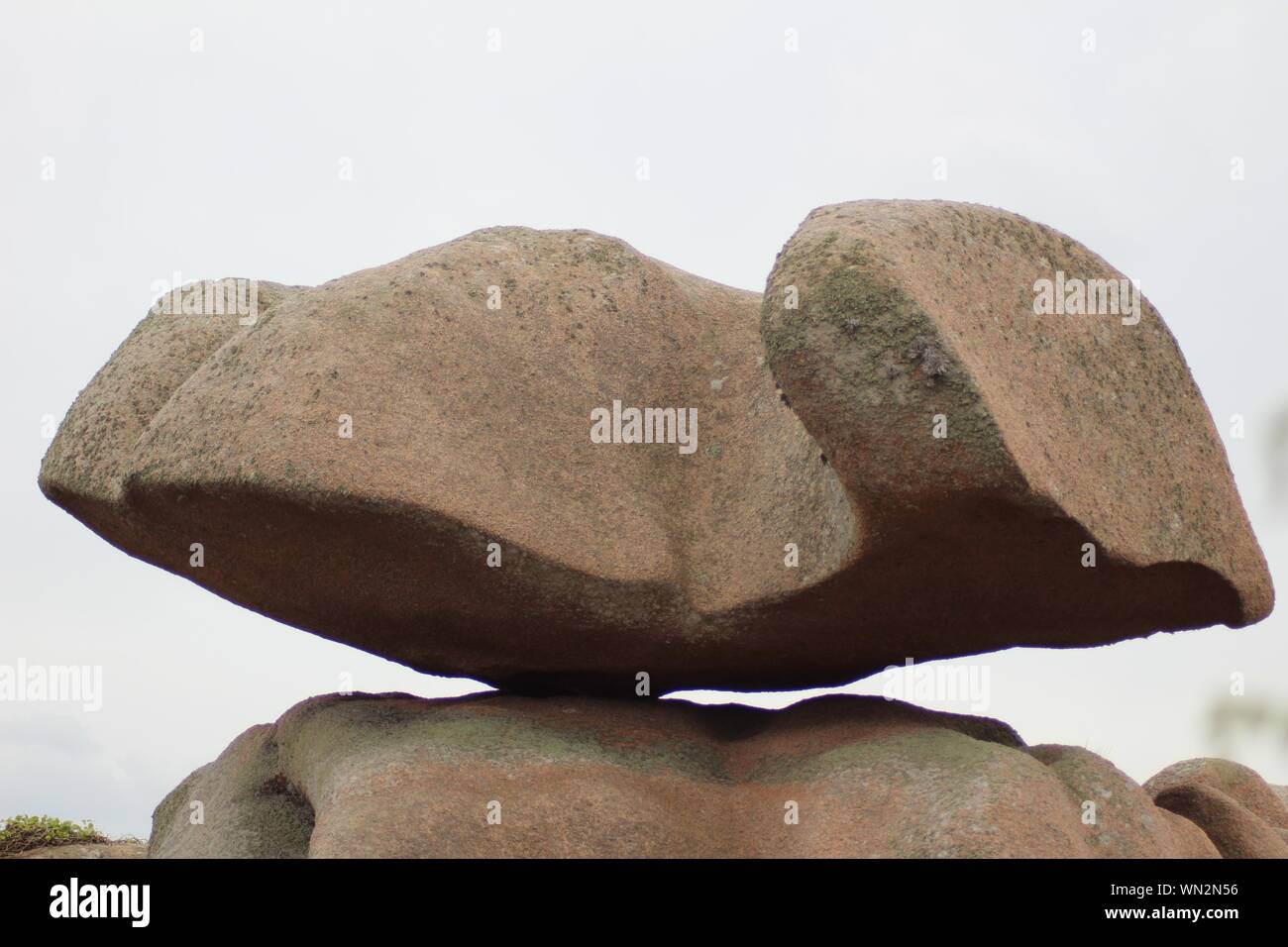 Nahaufnahme eines großen Felsens, der auf einer Klippe balanciert Mit einem klaren Himmel im Hintergrund Stockfoto
