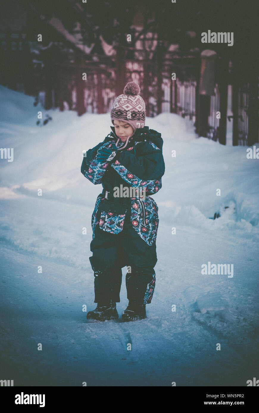 Süße Junge stehend Auf schneebedeckten Feld Stockfoto