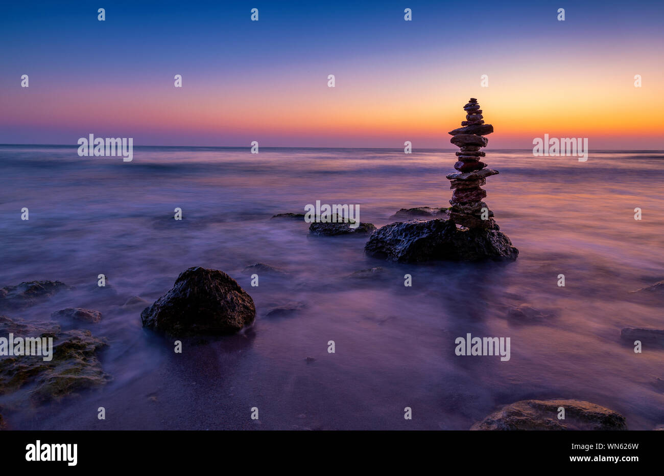 Stein Turm am Strand mit Sunrise im Hintergrund, langen Belichtungszeit. Stockfoto