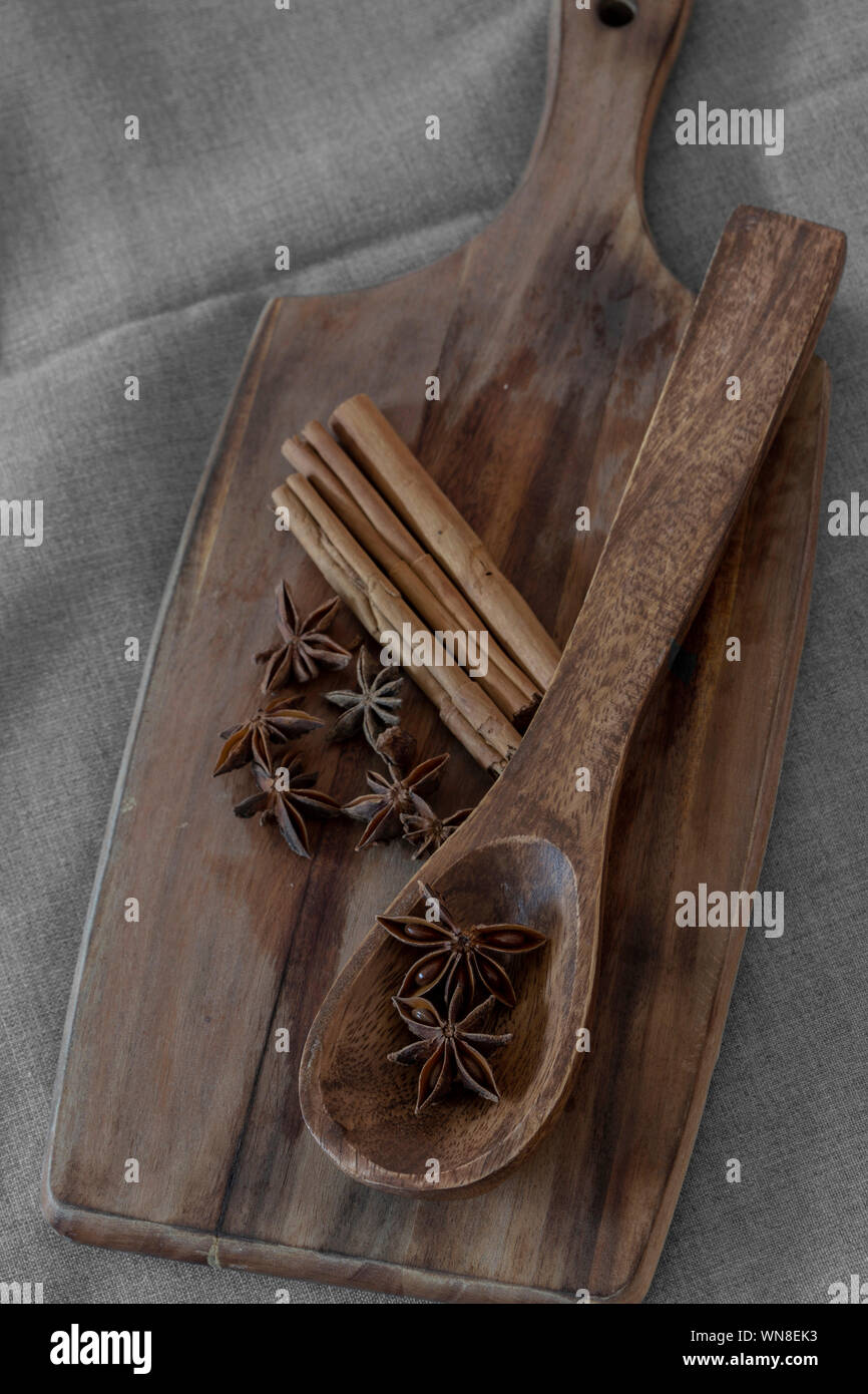 Sternanis in Löffel aus Holz mit Zimt auf Holz Schneidebrett. Aromatische Gewürze Stockfoto