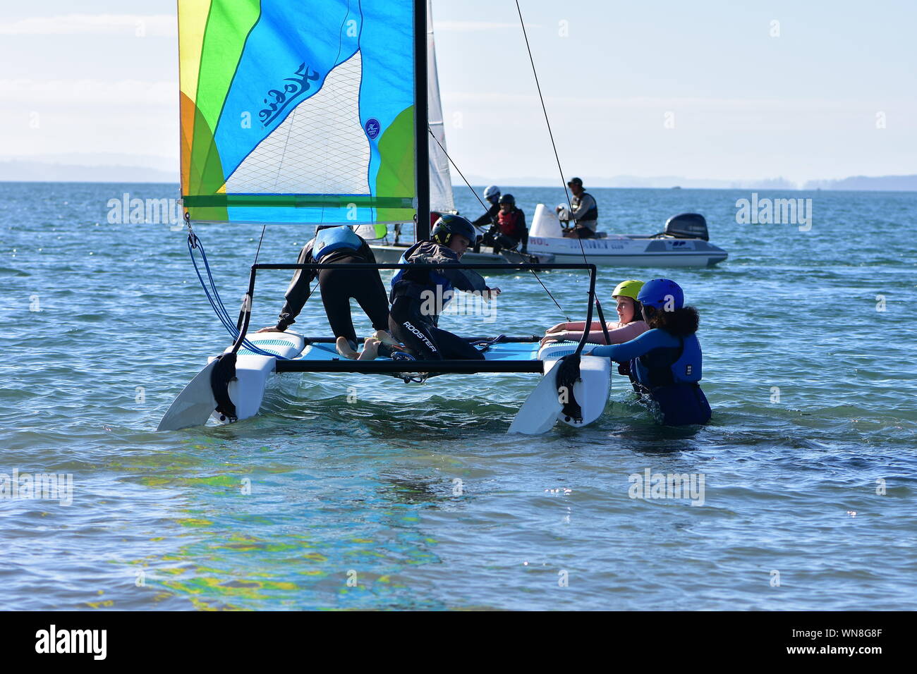 Mannschaft der jungen Mädchen ihre racing Segelkatamaran Boarding für die Ausbildung in der seichten Bucht. Stockfoto