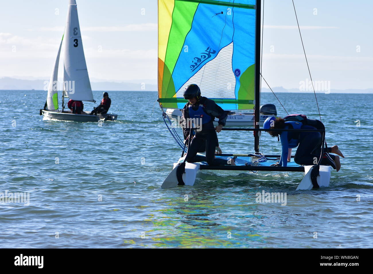 Mannschaft der Knaben ihre racing Segelyacht auf dem Wasser bereit für Ausbildung erhalten. Stockfoto