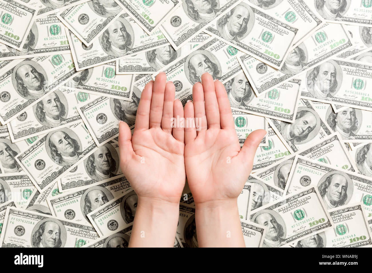 Blick von oben auf die weibliche Hände auf Dollar Hintergrund. Reichtum Konzept mit leeren Raum für Ihr Design. Betteln Geld Konzept. Stockfoto