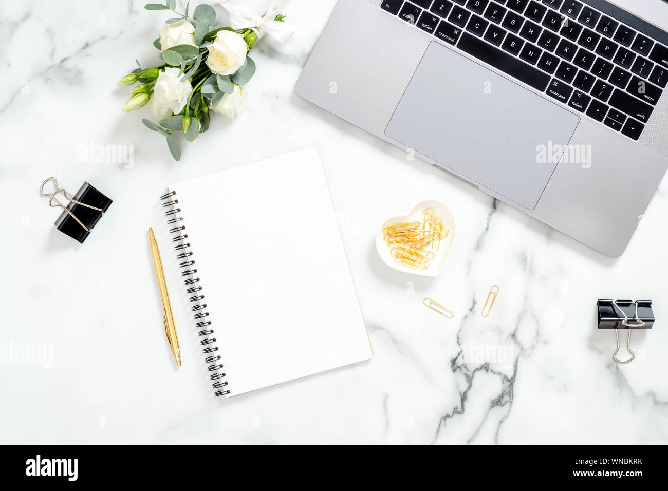 Marmor Büro Schreibtisch Tisch mit Laptop, Tagebuch, golden Schreibwaren, Bürobedarf, Blumen Blumenstrauß auf weißem Marmor Oberfläche. Flach, Ansicht von oben feminine backgrou Stockfoto