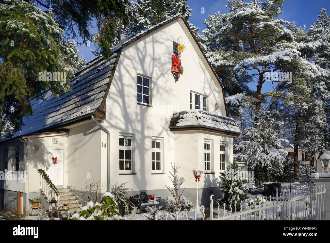 Housebreaker verkleidet als Weihnachtsmann, klettert ein Haus Wand in einem Haus durch ein Fenster zu Bruch Stockfoto