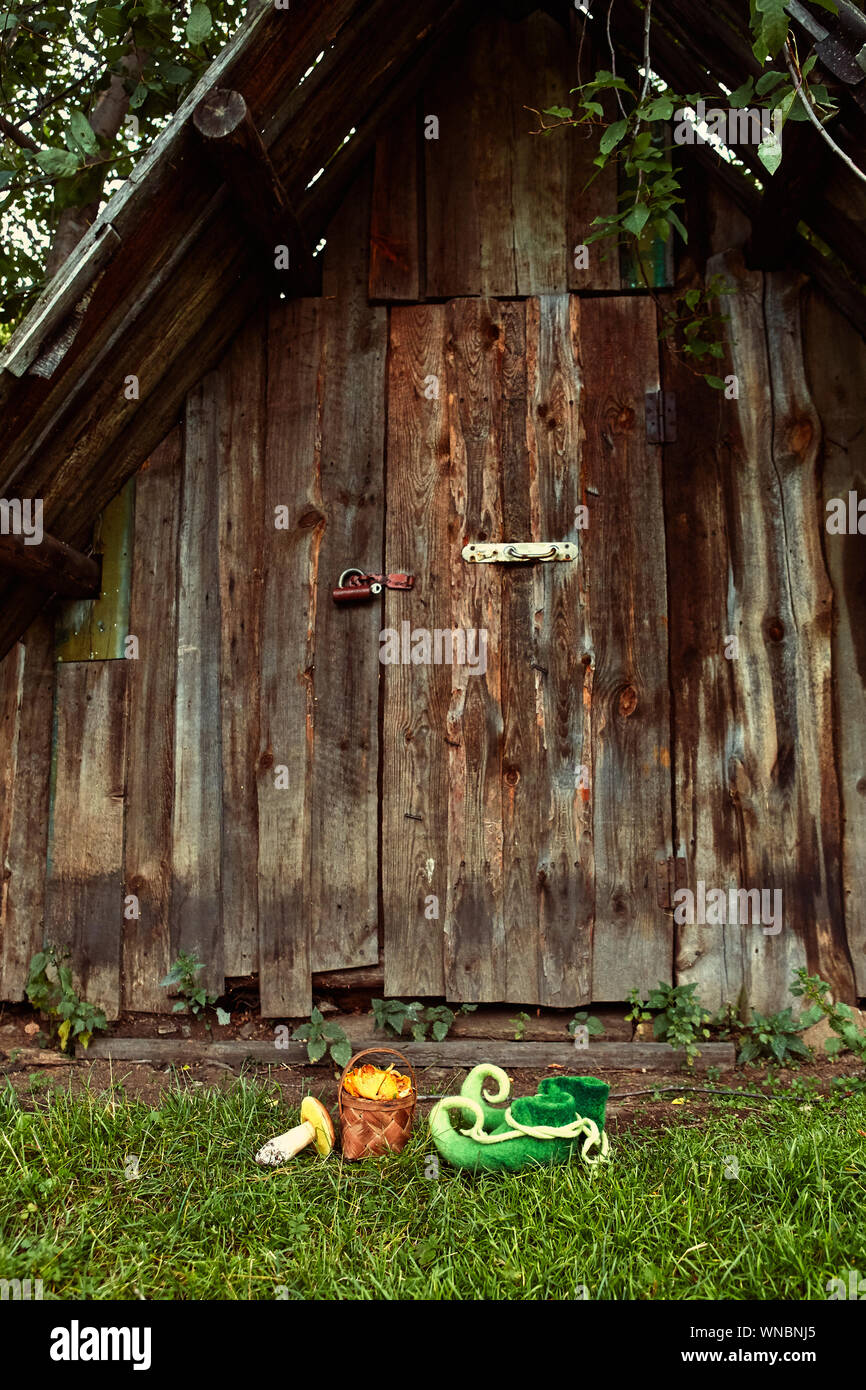 Eingang zur Wohnung eines Märchenwald Kreatur, elf oder Zwerg, mit grünen Stiefel vor der Haustür mit gebogenen Nasen links Stockfoto