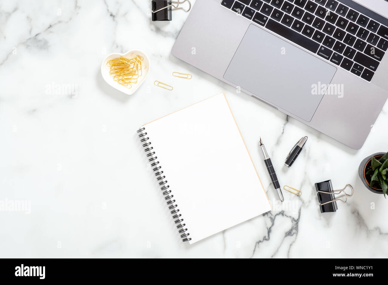 Büro Schreibtisch Tisch mit Laptop, leeres Papier notepad, Schreibwaren, sukkulente Pflanze auf weißem Marmor Oberfläche. Flach, Ansicht von oben feminine backgrou Stockfoto