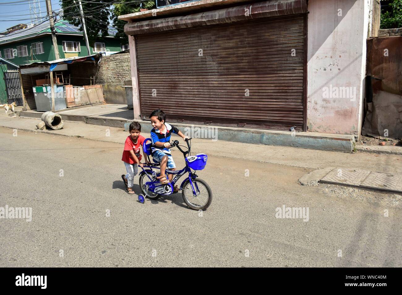 Srinagar, Indien. 06 Sep, 2019. Ein junges Zicklein reitet ein Fahrrad mit seinem Freund während der Schließung in Srinagar. Kaschmir-tal blieb unten für die 33 nachfolgenden Tag nach dem Abwracken von Artikel 370 durch die zentrale Regierung, die besonderen Status in Jammu und Kaschmir gewährt. Credit: SOPA Images Limited/Alamy leben Nachrichten Stockfoto