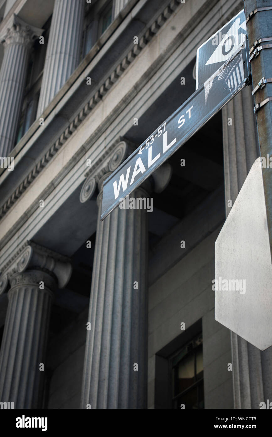 America Money, düsterer Blick auf ein Schild an der Wall Street gegen die kolonnadierte Fassade des alten Nationalbankgebäudes (heute Cipriani), NYC, USA Stockfoto