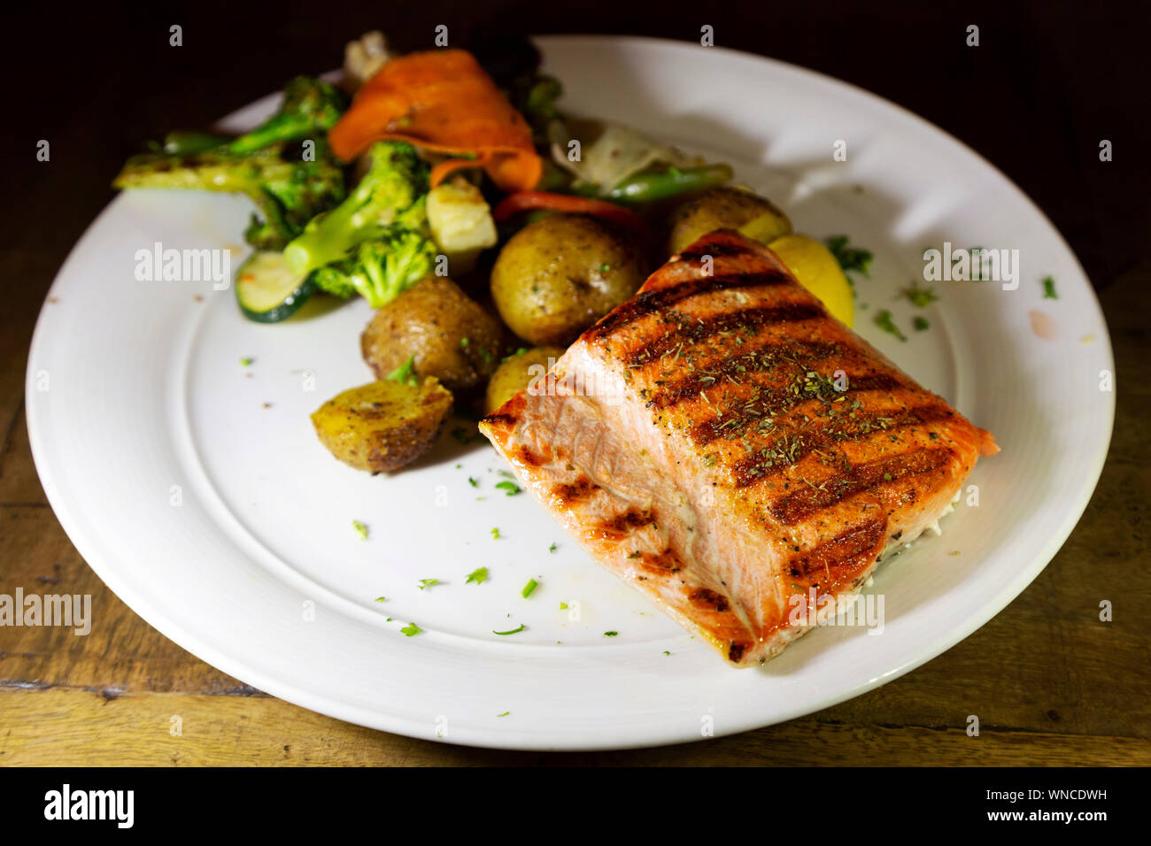 Wilde Alaska Lachs serviert in Whitehorse im Yukon, Kanada. Wird der Fisch gegrillt und mit Gemüse der Saison serviert. Stockfoto