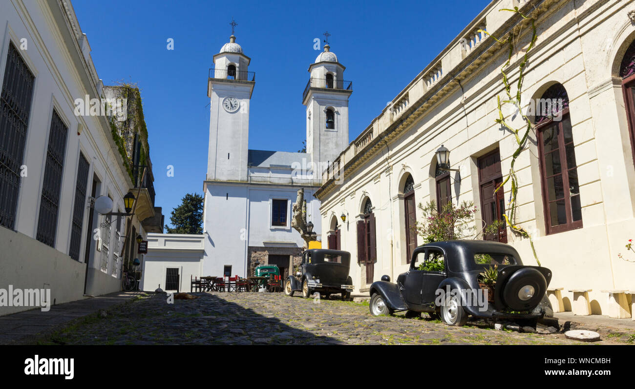 Veraltete Autos, vor der Kirche von Colonia del Sacramento, Uruguay. Es ist eine der ältesten Städte in Uruguay. Weltkulturerbe von der UNESCO im Jahr 1995. Stockfoto