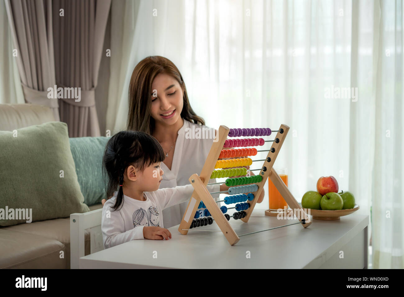 Gerne Asiatische junge Mutter und Tochter spielen mit Abacus, frühe Bildung zu Hause. Stockfoto