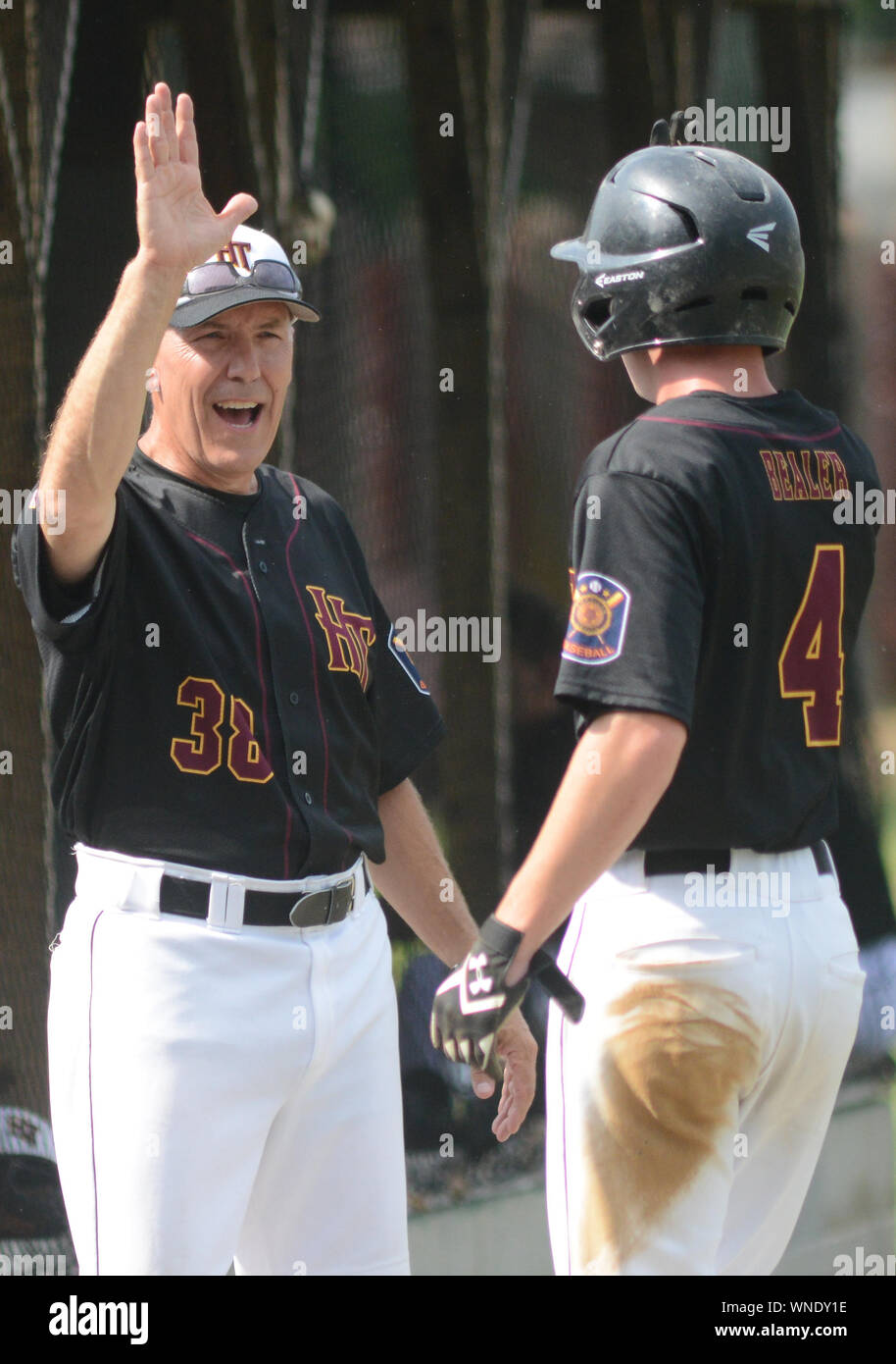 Hatfield's Ryan Bealer (4) wird von Trainer Jeff Klinger (38) nach erzielte gegen SOUDERTON in der ersten Inning Dienstag, 11. Juli 2017 bei AT gratuliert Stockfoto