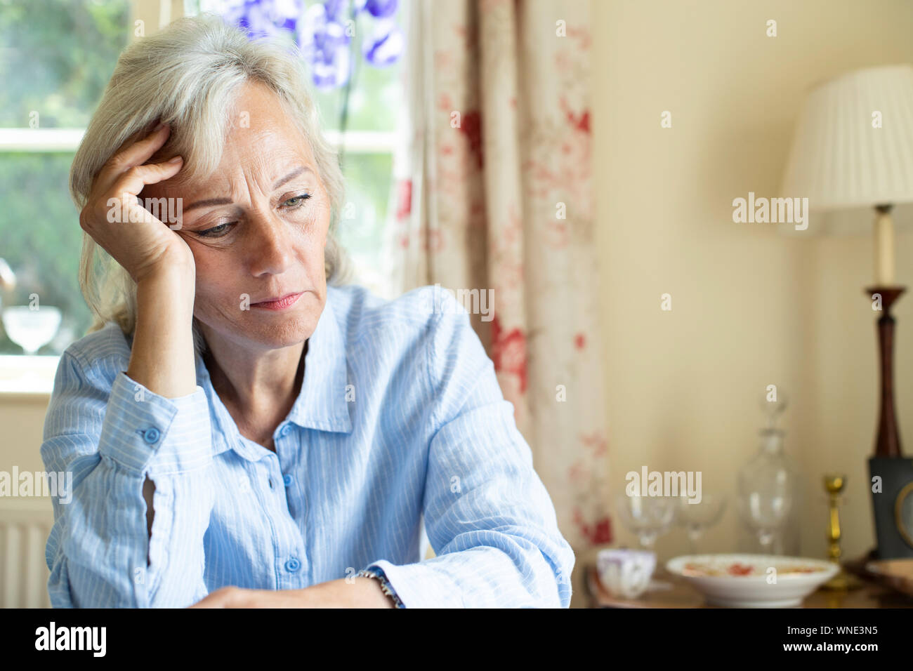 Ältere Frau Leiden mit Depressionen mit Kopf in den Händen zu Hause Stockfoto