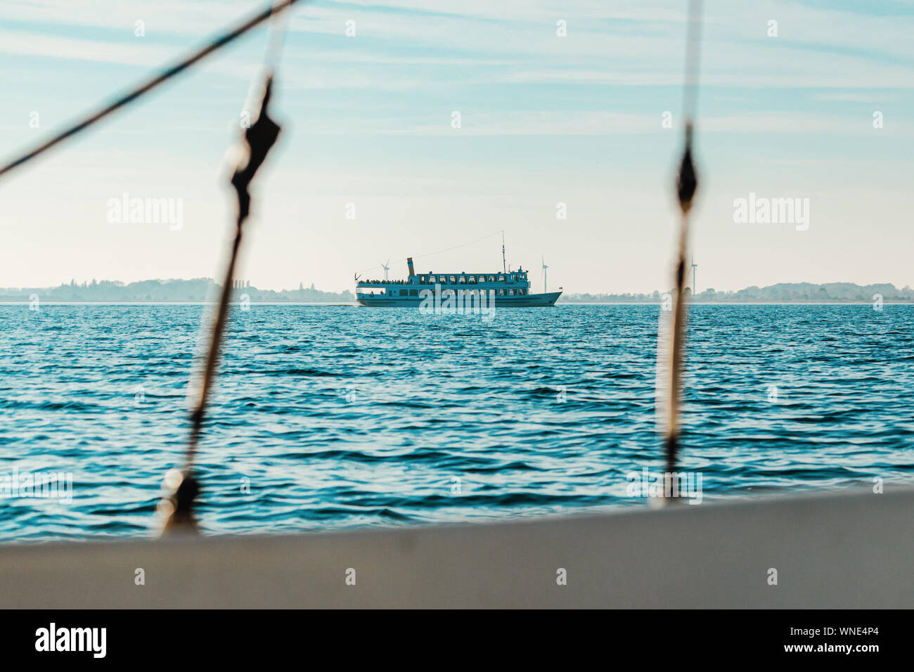 Schöne Fähre am Horizont, von einem kleinen Segelboot gesehen Stockfoto